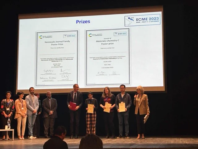 Photo of poster prizes being awarded at E-C-M-E 20-23