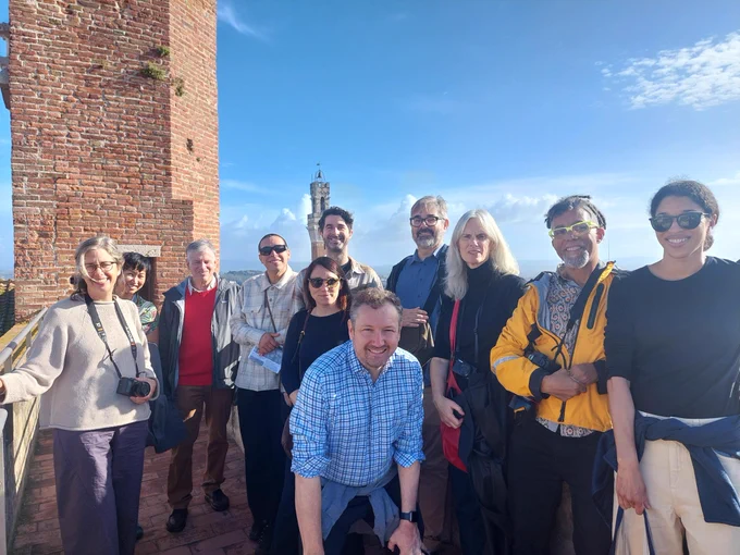 A group of people pose on a rooftop in Siena, Italy