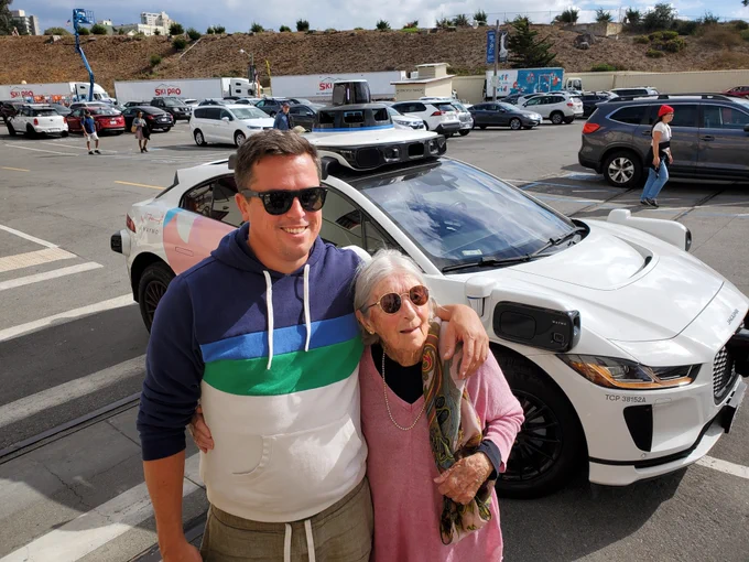 Yours truly and my amazing 96 year old grandma, in front of a Waymo robotaxi in San Francisco
