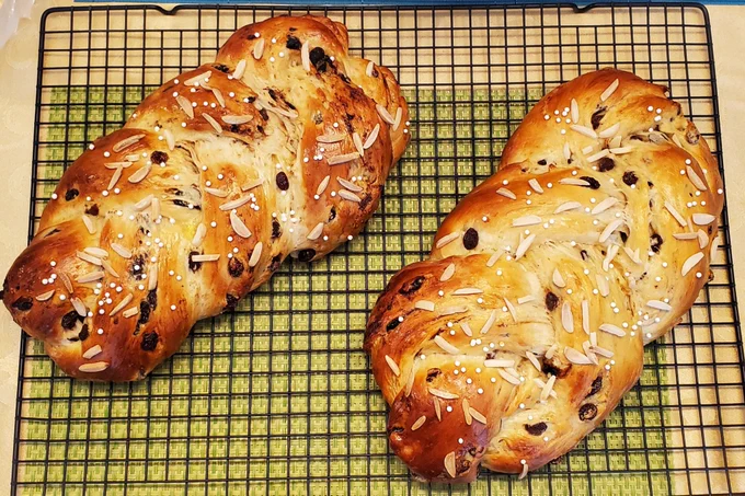Golden brown braided sweet German yeast bread. Containing raisins, dried cherries, candied ginger. Decorated with shivered almonds.