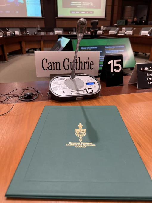 A picture of my desk at the finance committee in Ottawa with my binder of speaking notes and my name tag.