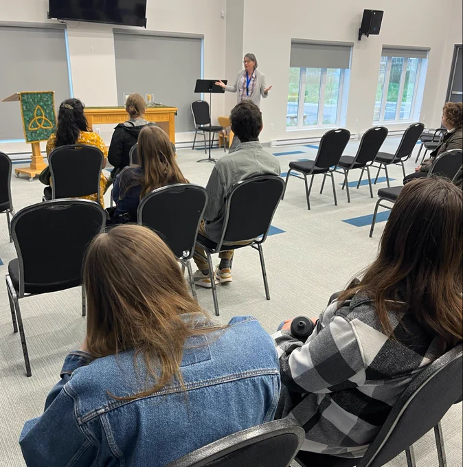 Photo of Rev. Shawn Redden speaking in front of a group of seated university students.