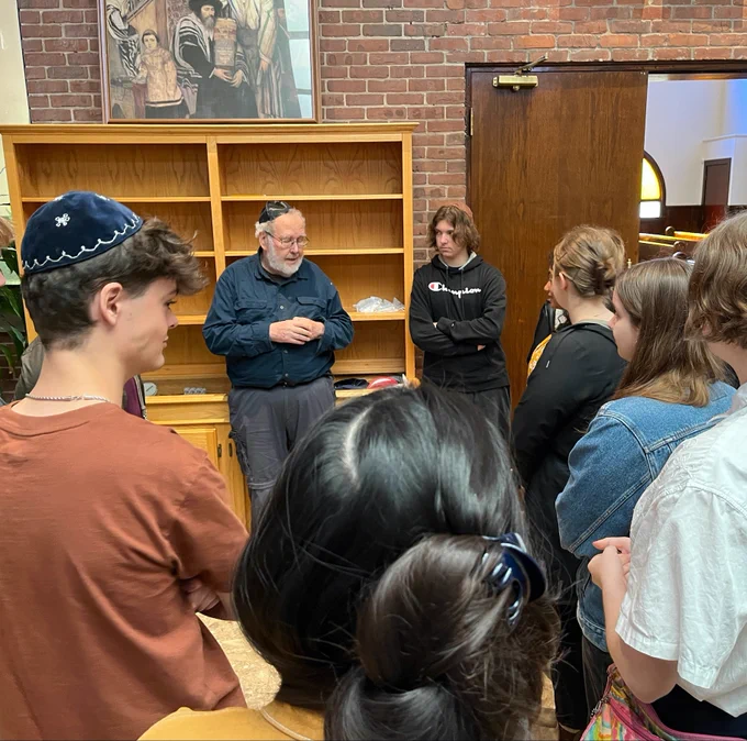 Photo of university students gathered around Frances Weil from Tiferes Israel Synagogue.