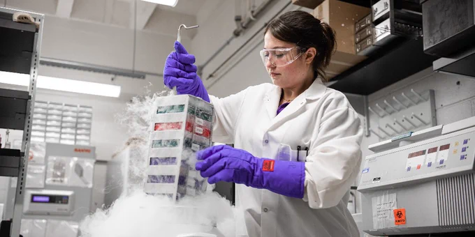 A K-State researcher works in a lab with equipment.