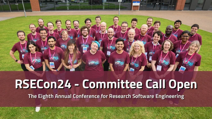 The 2023 RSE Conference Volunteers and Committee Members, standing on the grass outside the conference venue in Swansea. There are approximately 30 people, all in maroon RSECon23 T-shirts and smiling up at the camera.