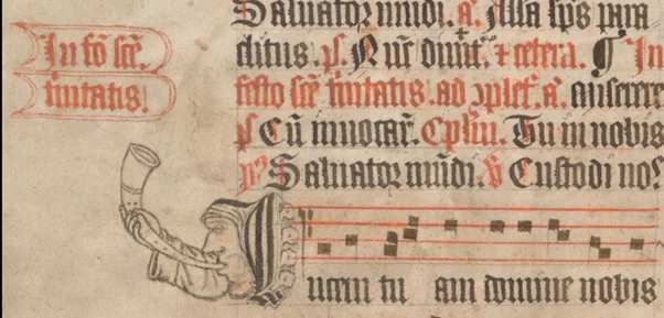 Image of a man blowing a horn surrounded by black and red letters and lines of musical staves in red, from TCD MS 77, f. 124v. 