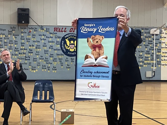 State Superintendent Richard Woods presenting the Literacy Leaders banner to New Georgia Elementary!