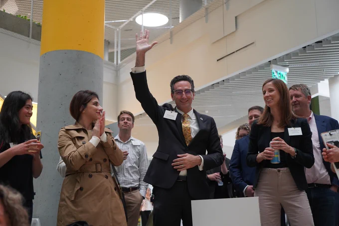 Photo of State Rep. Tommy Vitolo raising his hand at the 2022 BE  Green Building Showcase at Harvard University's Science & Engineering Complex.