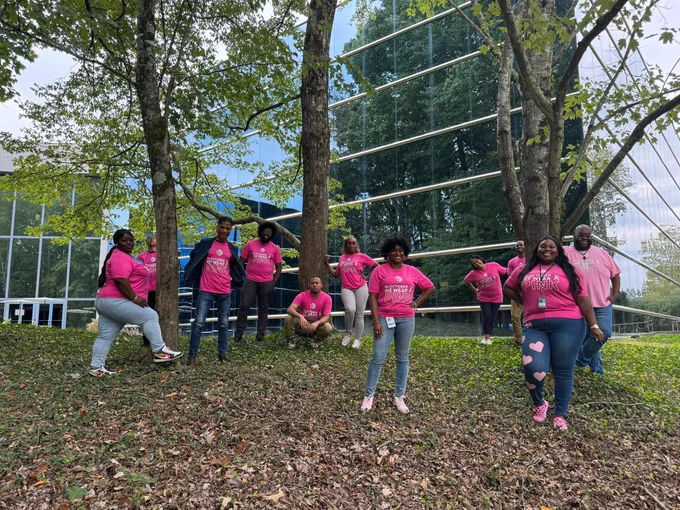 Team members outside the AT&T office in pink shirts for breast cancer awareness