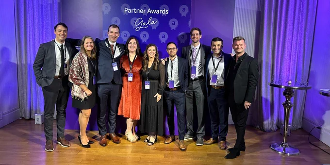 Picture of a group of nine people posing for a photo at the Amazon Ads Partner Awards Gala. 