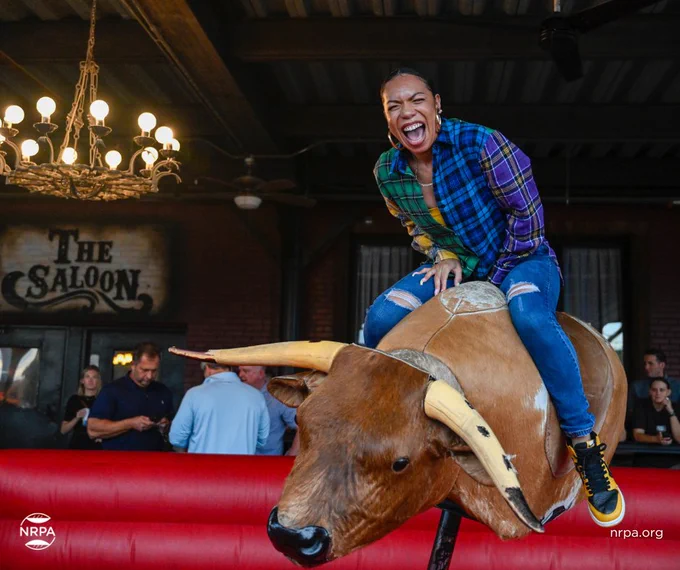 Attendee riding the mechanical bull at the Gilly's opening reception party.