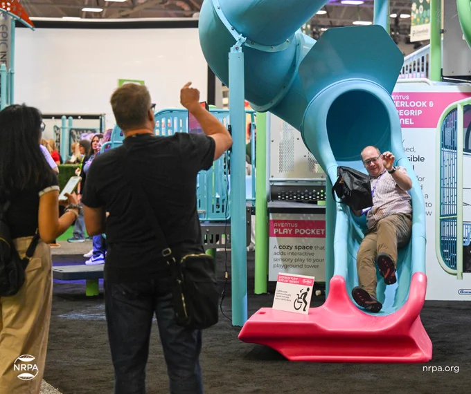 Attendee trying out a slide on the exhibit floor.