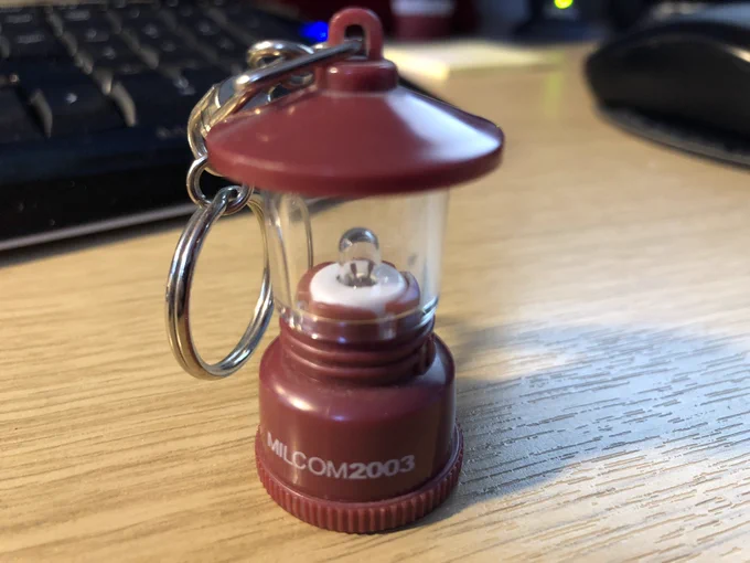 Keyring from MILCOM 2003 conference Boston in shape of a working latern with and incandescent bulb and LR44 battery