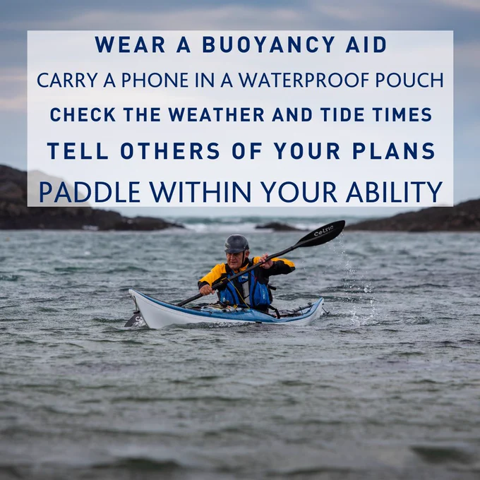A male kayaker with yellow sleeves is kayaking in the sea.