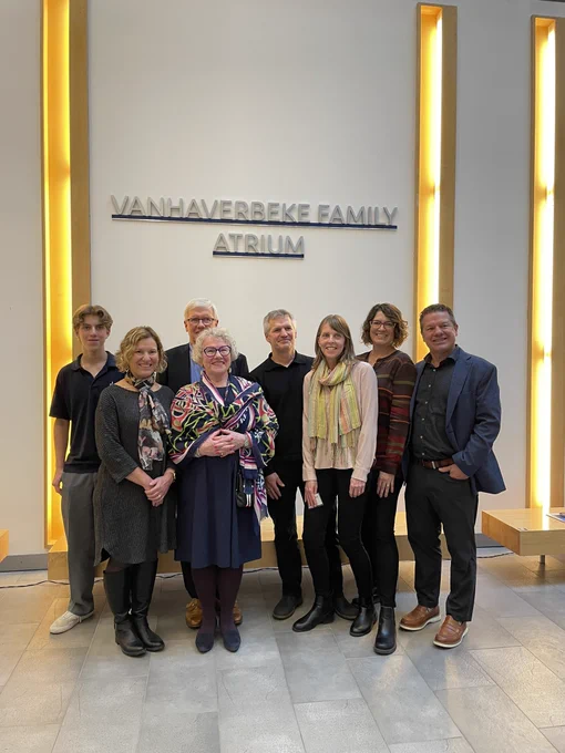 The Vanhaverbeke family in front of the Vanhaverbeke Family Atrium sign.