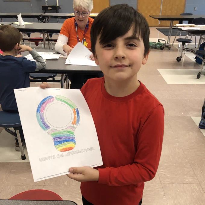 Youth posing with image of lightbulb coloring page.