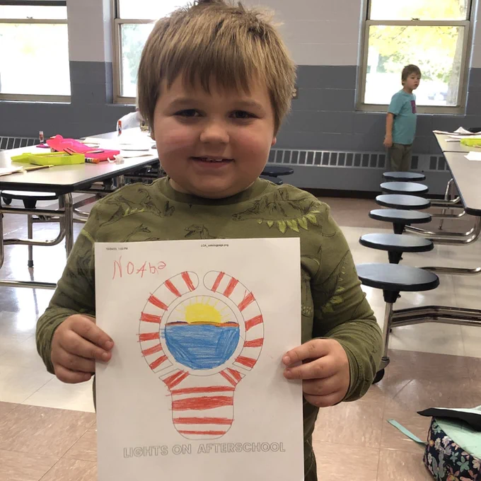 Youth posing with image of lightbulb coloring page.