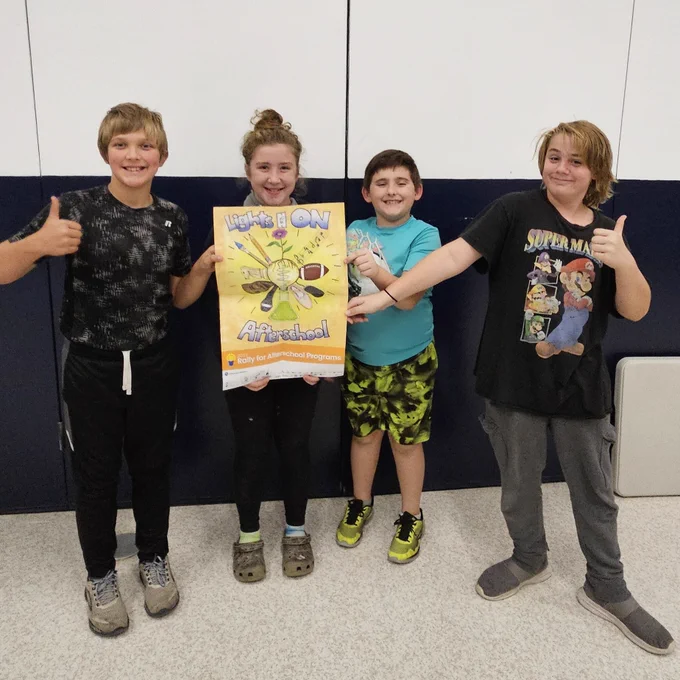 Youth posing with Lights On Afterschool poster.