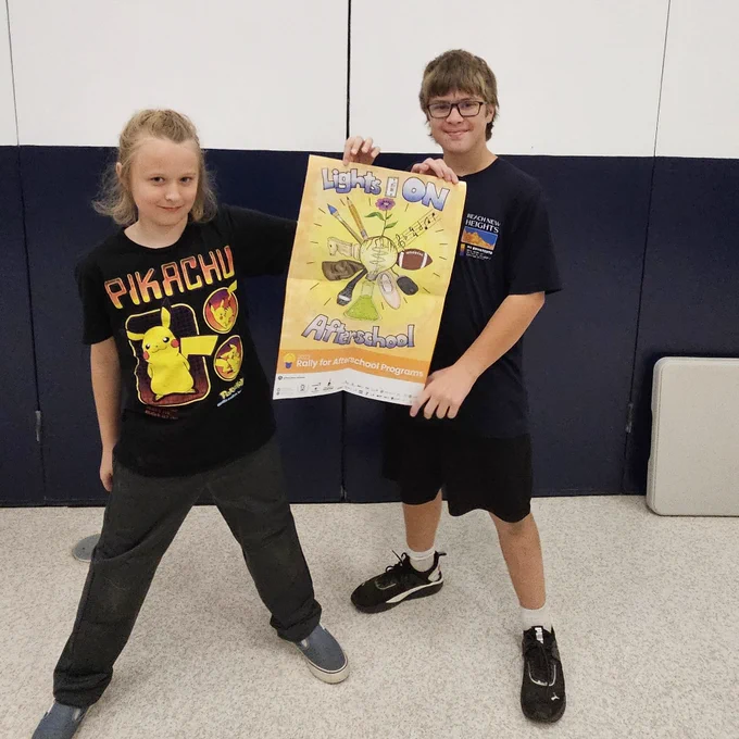 Youth posing with Lights On Afterschool poster.