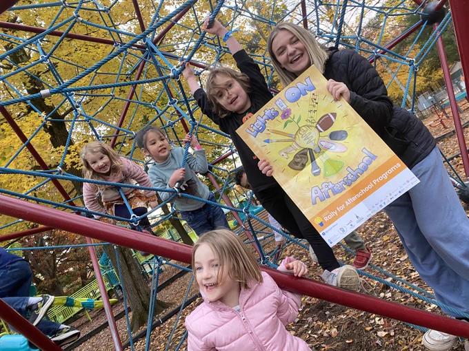 Kids posing on climbing structure at playground and a Lights On Afterschool poster.