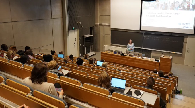 Event participants sitting in a lecture hall listening to a presentation