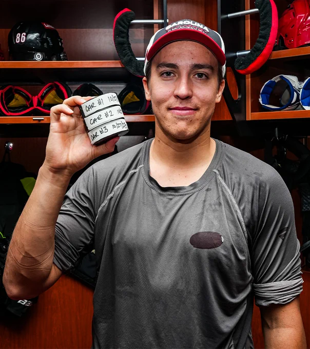 Photo of Turbo holding his three pucks from his hat trick
