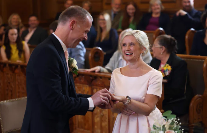 Kelly and MiKe getting getting married. Mike is placing the ring on her finger