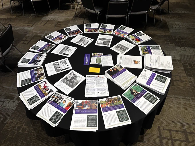Round table with a couple dozen stacks of paper resources. 