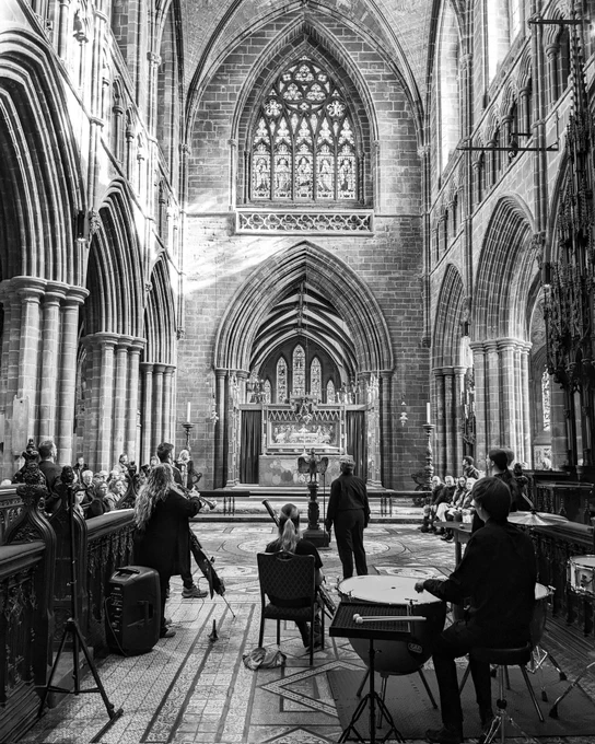A black and white photo of the cathedral quire showing a group of performers from behind.

Image: © Emma Knight.