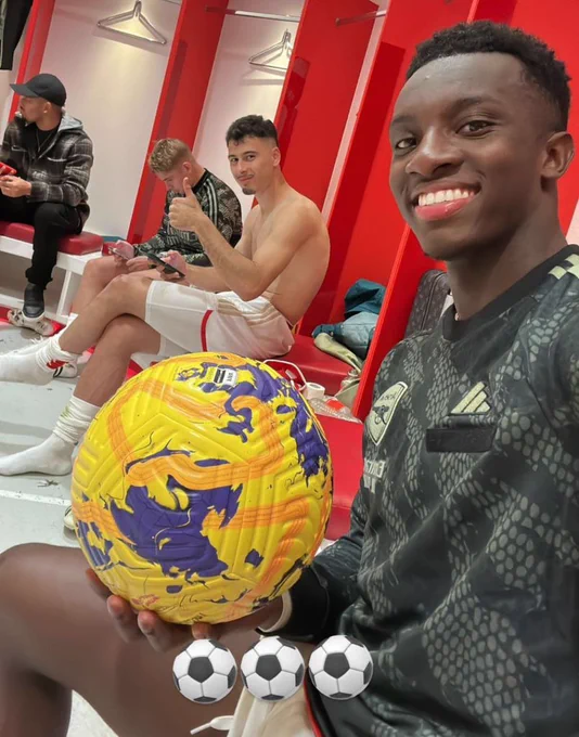 Eddie Nketiah taking a selfie with the match ball after his hat-trick, with Martinelli giving his seal of approval in the background with a thumbs up.