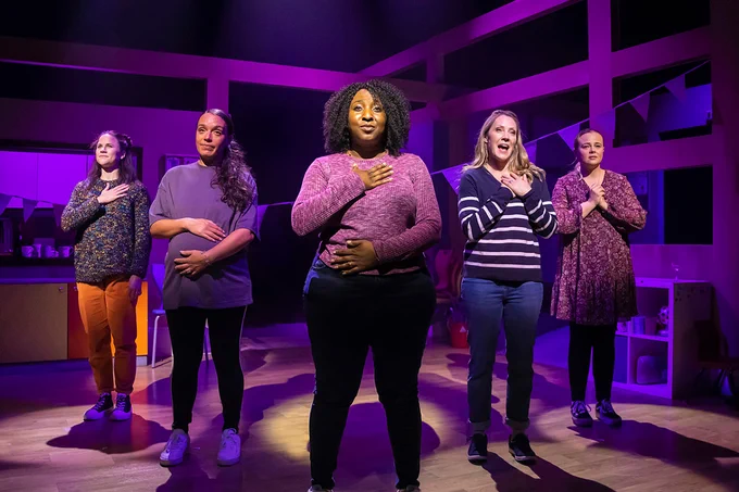 A photo showing five women on stage in a line
