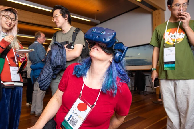 A visitor with beautiful blue hair and a red shirt enjoying AR at #visap2023