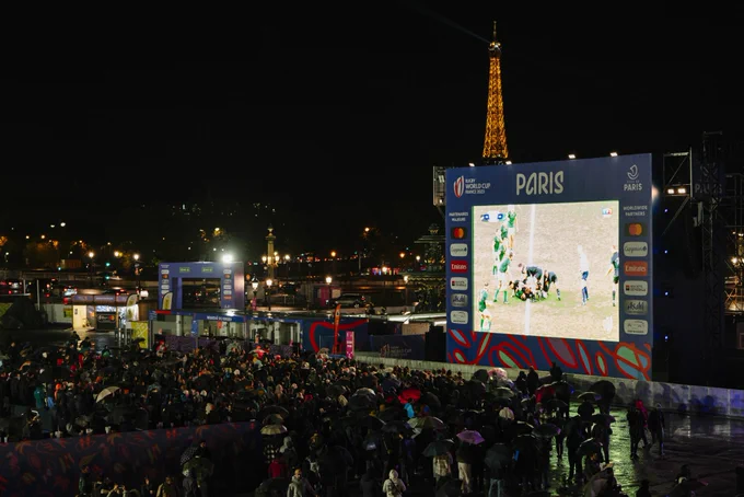 Foule devant l’écran géant sur la place de la concorde avec la Tour Eiffel au fond.