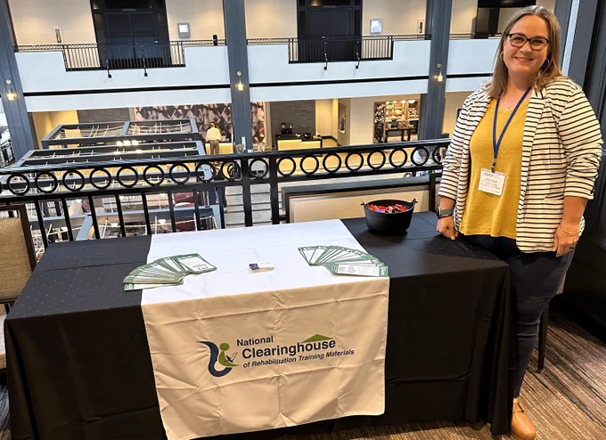 Heather Servais standing at the NCRTM booth at the CSAVR conference.
