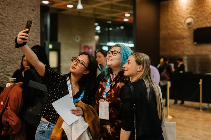 One woman taking a selfie of a group of three women