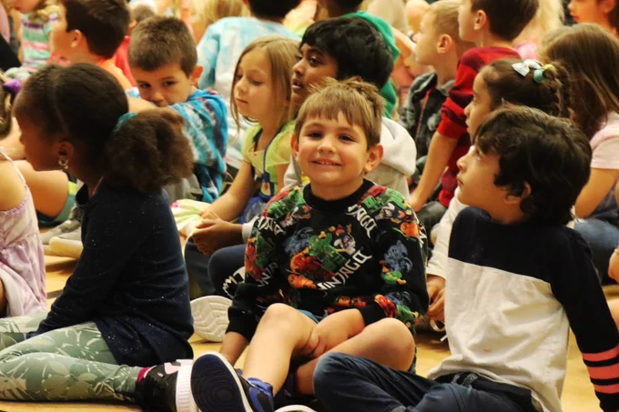 A Rockwood student smiles during a puppet show about friendship in his school gymnasium.