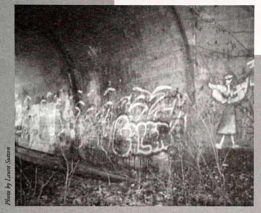 photograph of a bridge underpass with graffiti on it. Drawing of an angel and graffiti in the underpass to the abandoned bridge near E. Main Street in Jamestown, North Carolina. The ghost "Lydia" is believed to haunt the site. Image from the North Carolina Folklore Journal, Midwinter 2000.