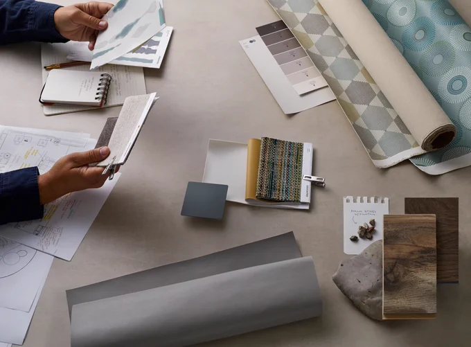 A designer at work compares various textiles, textures and palettes.
