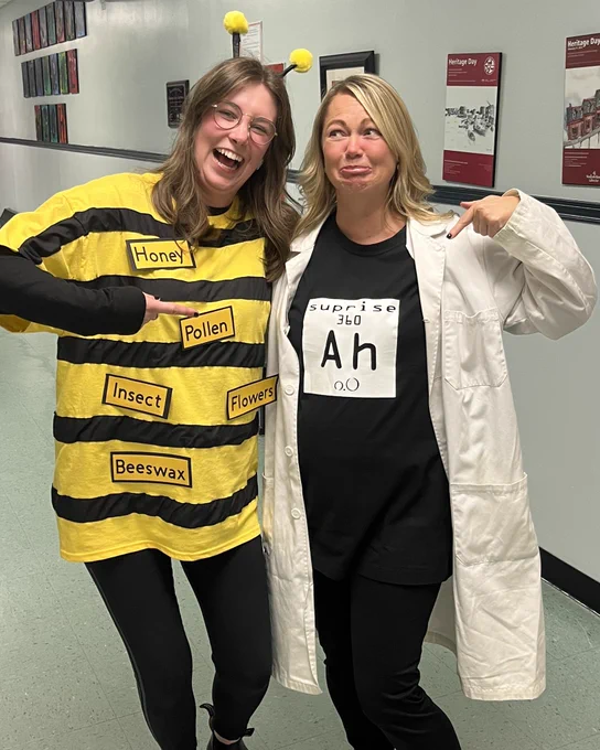 Two teachers dressed for Halloween. One as a “spelling bee” and one as the “element of surprise”