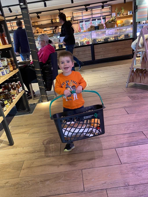 Oscar carrying a basket of goodies in the bakery shop