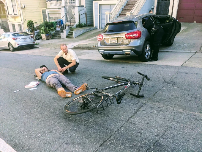 cyclist on the ground after being hit by a driver pulling out of a driveway
