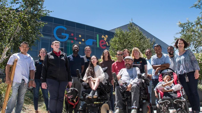 Members of Google’s Disability Alliance in front of a Google logo that has been altered to reflect braille, ASL, and a wheelchair user.

Pictured in the group photo from left to right are: Son Huynh, Paula Conn, Nicole Torcolini, John Angelo, Jim Hogan (DA Vice President, Accessibility in Technology), Aubrie Lee (DA President), Peter Saathoff-Harshfield, Vaibhav Vaish, Paulette Penzvalto (DA Head of Operations), Mohammad Izadi, Katie Wainwright, Yogesh Kalley, Angshuman Goswami with his son Achin, Ajit Narayanan, and Debbie Newhouse (DA Co-Founder).