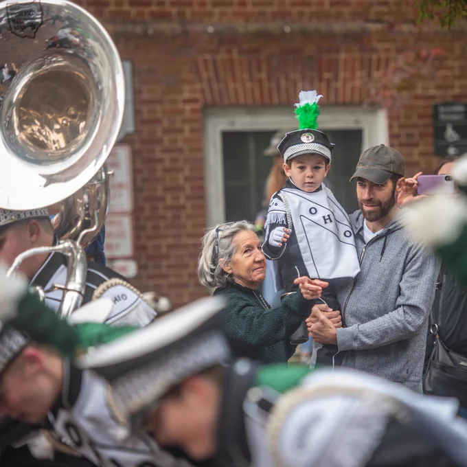 Young child in Marching 110 uniform watches the Ohio University Marching 110.