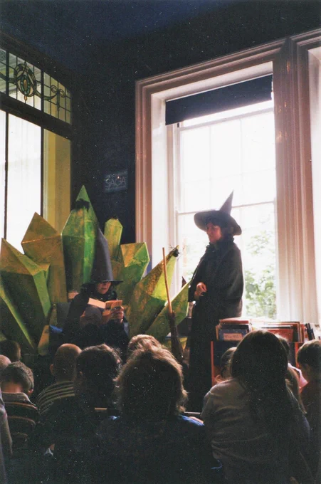 Two librarians dressed as witches read to a group of children