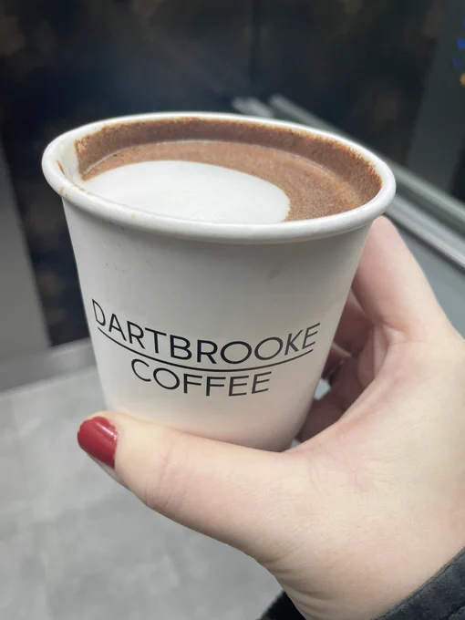 Dartbrooke coffee branded cup with hot chocolate inside and white milk foam on top