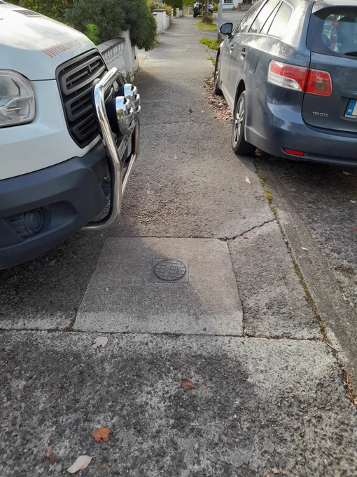 Van and car parked so that pavement is narrowed