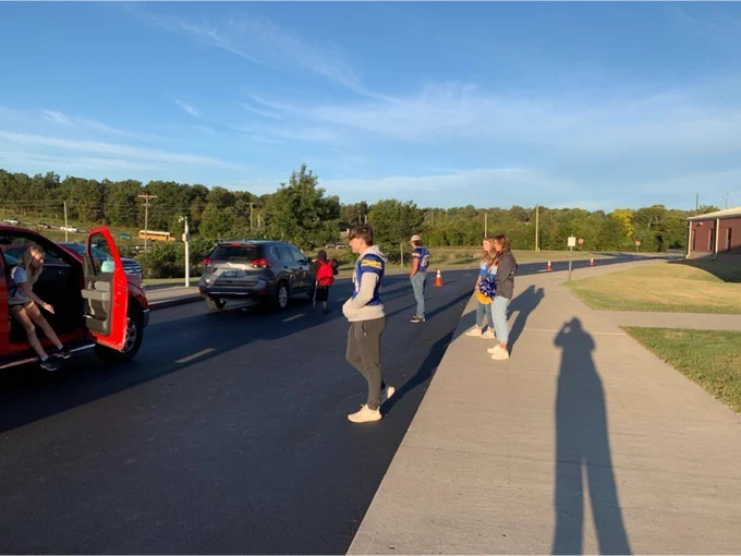 boys helping kids get out of cars