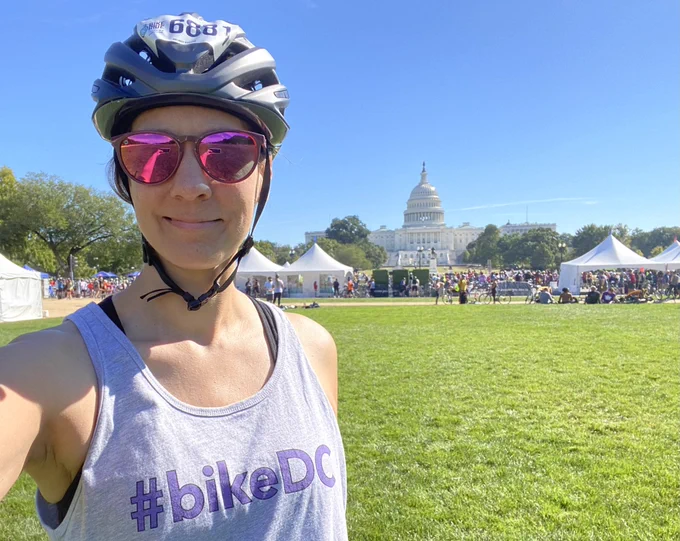Woman in front of US Capitol wearing a bike helmet and #bikedc shirt