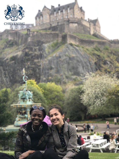 Image of Chevening Scholar called Shahnoza with her friend sitting in front of Edinburgh castle.
