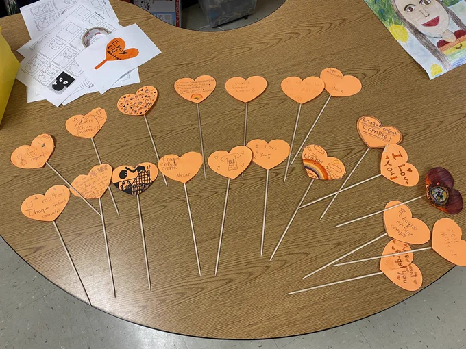 Orange paper hearts on sticks with messages of support for residential school survivors.
